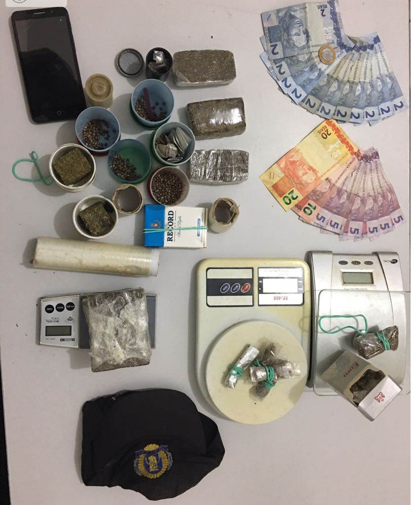 Com ele foram apreendidas três balanças de precisão, tabletes de maconha, dinheiro em espécie e um boné alusivo à Polícia Militar | Foto: Divulgação/ PM