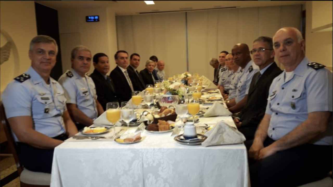 Ao fundo, Jair Renan Bolsonaro participa com o pai de reunião com generais, almirantes e brigadeiros da FAB | Foto: divulgação/FAB